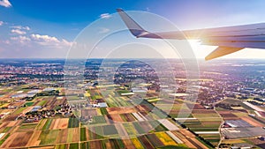 Airplane windows view above the earth on landmark down. View from an airplane window over a wing flying high above farmlands and