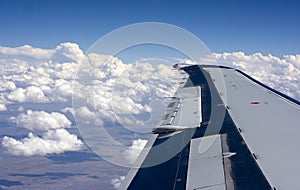 Airplane wing above the clouds photo