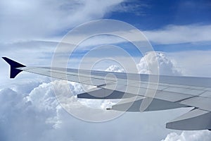 Airplane Wing Against A Blue Cloudy Sky