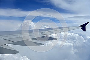 Airplane Wing Against A Blue Sky with White Clouds