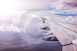 Airplane wing through the aircraft window. Greenhouse effect, global warming. Sunshine