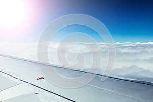 Airplane wing through the aircraft window. Greenhouse effect, global warming. Sunshine