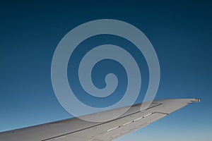 Airplane wing with the beautiful blue sky in the background