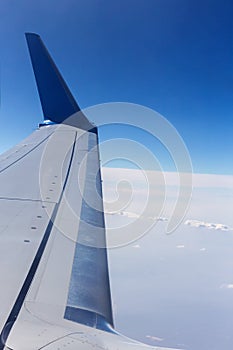 Airplane wing in the blue sky