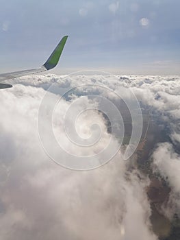 Airplane wing and clouds in the blue sky