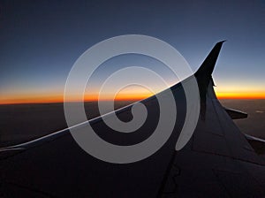 Airplane wing at dusk, colorful skyline