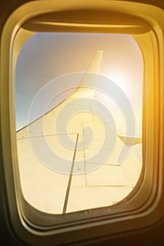 Airplane wing in flight through porthole window