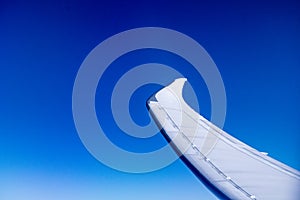 Airplane wing in flight with winglet in a blue sky