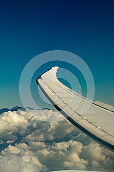 Airplane wing in flight with winglet over the clouds