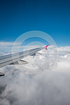 Airplane wing flying above the clouds