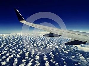 Airplane wing flying above clouds