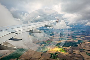 Airplane wing flying above the fields