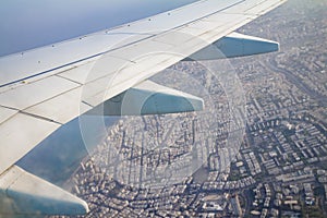 Airplane wing on the sky and over land with building of Tel Aviv city and the Mediterranean sea