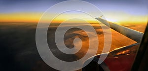 Wing of an airplane flying at sunset.