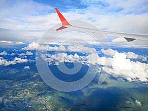 Airplane wing view with a cloud background,mountain and city.