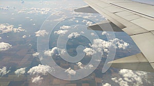 Airplane wing view out of the window on the cloudy sky background. Holiday vacation background. Wing of airplane flying above