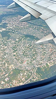 Airplane wing view out of the window on the cloudy sky The Earth and the blue sea. background. Holiday vacation background. Wing