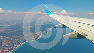 Airplane wing view out of the window on the cloudy sky The Earth and the blue sea. background. Holiday vacation background. Wing