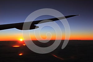 Airplane wing with warn and cold colors sky, beautiful sunrise light