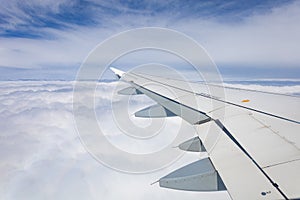 AIRPLANE WING BETWEEN WHITE CLOUDS AND BLUE SKY 0009
