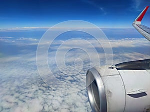 Airplane Wing through the window aircraft during flight with a blue Sky