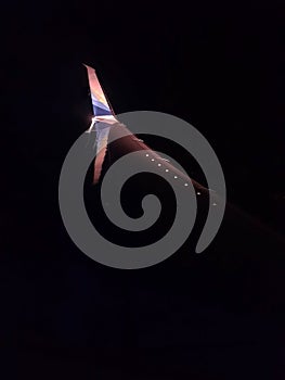 Airplane winglet reflection in dark night cruising above the clouds