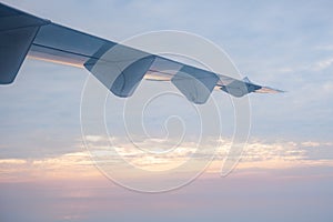 airplane wings when flying in sky at sunrise time,transportation and travel concept.