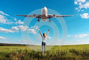 Airplane and woman on the field at sunset in summer