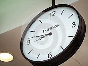 An airport clock showing London time zone