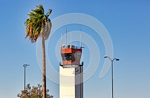 Airport Control Tower with accompanying palm tree and lamp posts photo