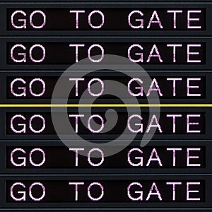 Airport departure board with go to gate sign.