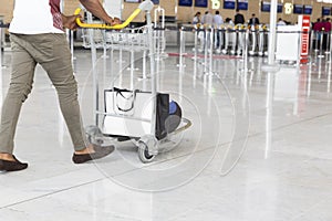 Airport luggage Trolley with suitcases, unidentified man woman walking in the airport, station, France.