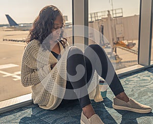 Airport phone travel woman using mobile smartphone while waiting for plane flight texting sms message. Technology and travel