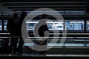 Airport rush: people with their suitcases walking along a corridor