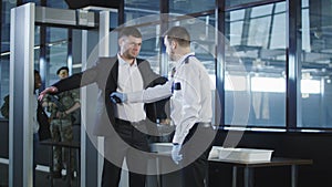 Security agent using a metal detector on a man photo