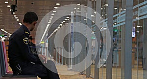 Airport Security in dark blue uniform sitting on the chair in the Yangon International Airport.