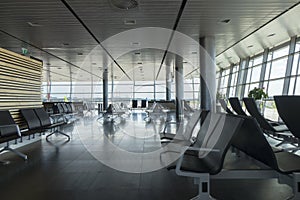 Airport terminal with empty chairs for waiting departure.