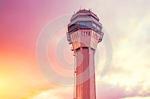 Airport traffic control tower lonely with background of the sunset orange pink light sky and clouds