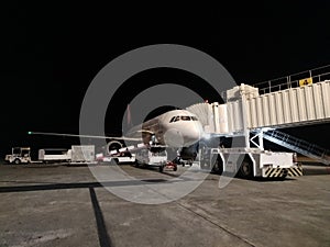 Airport vehicle transporting cargo to airplane at night.Luggage delivery catering service at night