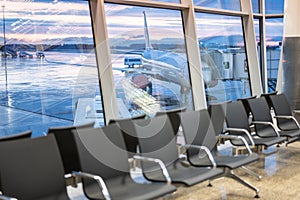 Airport waiting area. plane and dramatic sky behind the windows. modern airport terminal waiting room