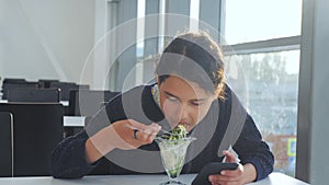 Airport waiting for a flight by plane. Teen girl eats salad and looks smartphone. Internet in a lifestyle cafe. terminal