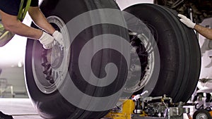 Airport worker checking chassis. Engine and chassis of the passenger airplane under heavy maintenance. Engineer checks