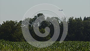 airship flying over rural forest and agricultural field