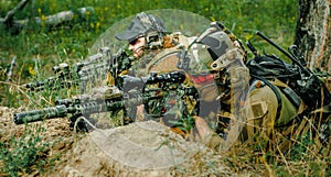 Airsoft sniper men with guns lay on hill. Sniper and aimer on operation photo