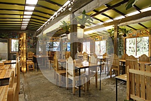 Airy and green indoor restaurant with wooden furniture