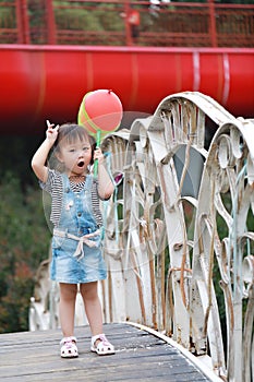 Aisa cute naughty lovely child girl play with balloon have fun outdoor in summer park happy smile happiness funny childhood