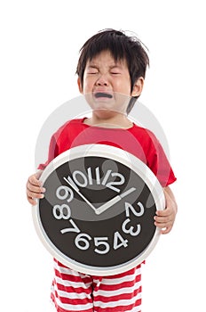 Aisan boy crying and holding clock photo