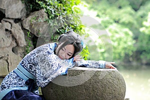 Aisan Chinese woman in traditional Blue and white Hanfu dress, kill time in a famous garden