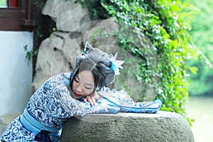 Aisan Chinese woman in traditional Blue and white Hanfu dress, kill time in a famous garden