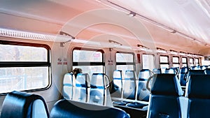 Aisle inside passenger car of suburb train with comfortable blue seats and windows. Traveling by railway. Railroad trip